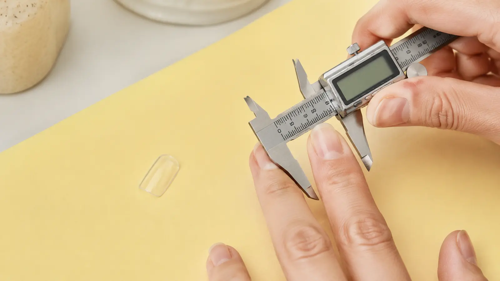 Measuring the widest point of a natural nail with a digital caliper before choosing a press-on size.